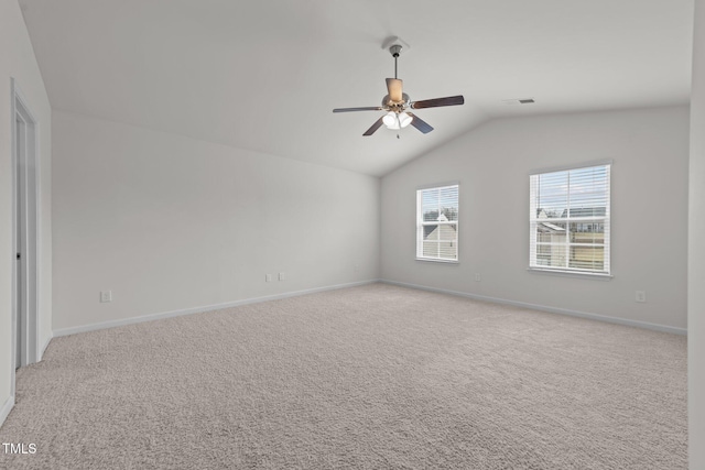 empty room with visible vents, baseboards, light colored carpet, lofted ceiling, and a ceiling fan