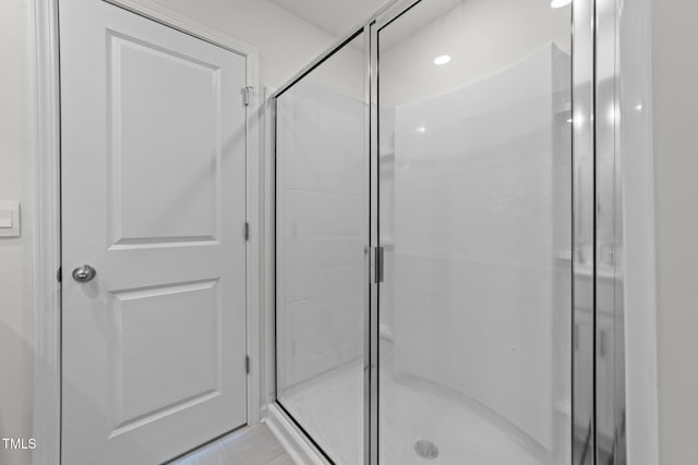 bathroom featuring tile patterned flooring and a shower stall