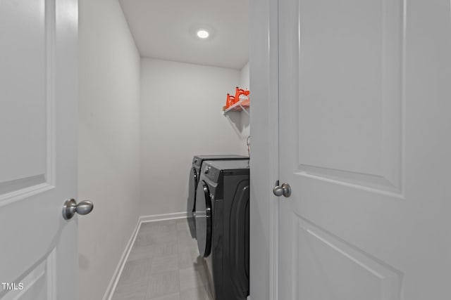 laundry room with baseboards, separate washer and dryer, and laundry area