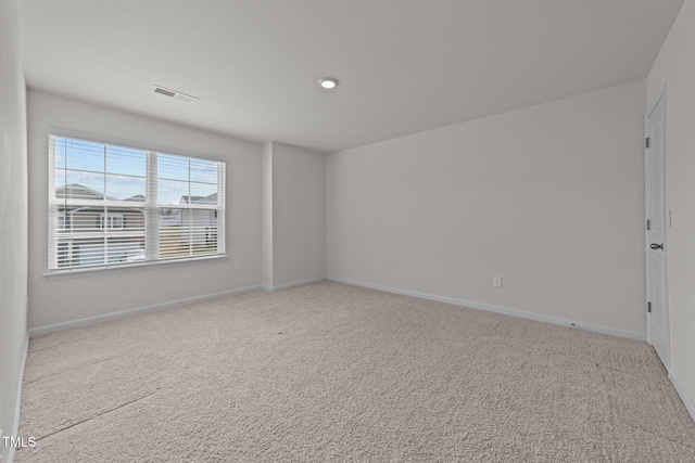 carpeted empty room featuring visible vents and baseboards