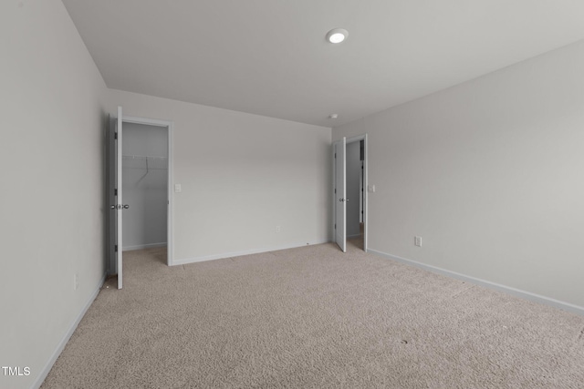 empty room featuring light colored carpet and baseboards