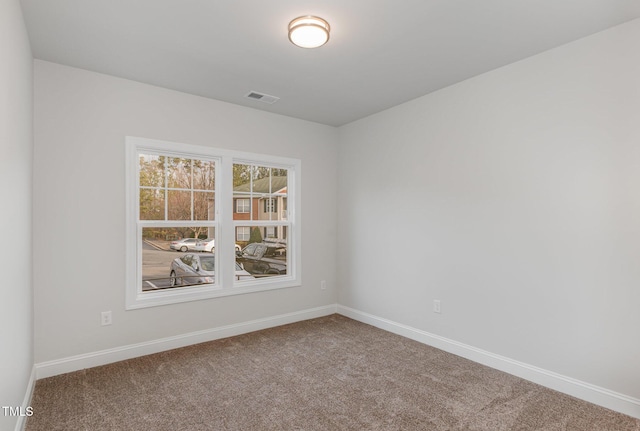 carpeted empty room with visible vents and baseboards