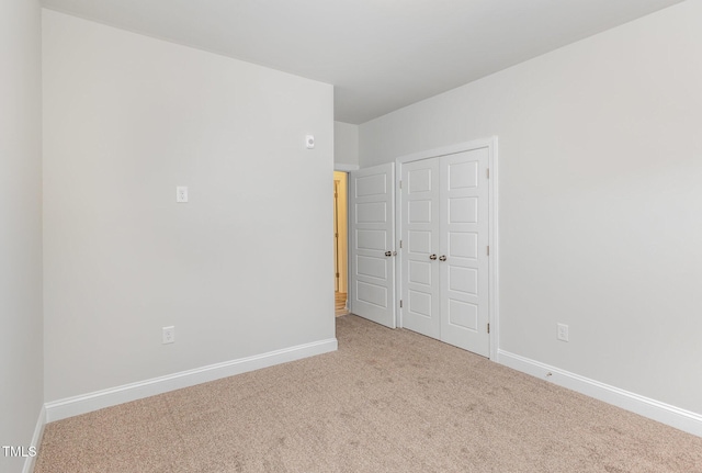 unfurnished bedroom featuring a closet, baseboards, and carpet