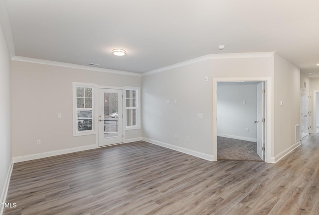 unfurnished room featuring crown molding, wood finished floors, and visible vents