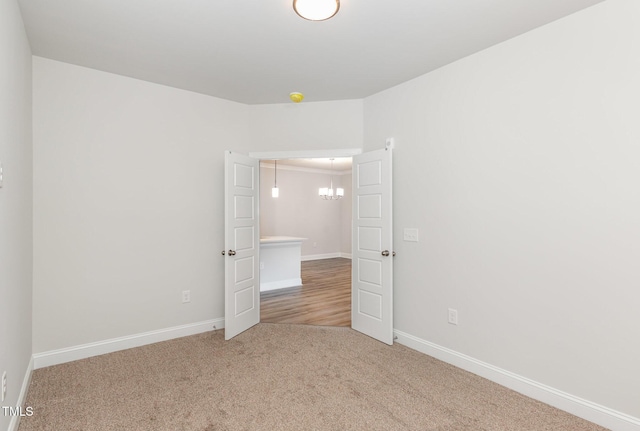 empty room featuring carpet and baseboards