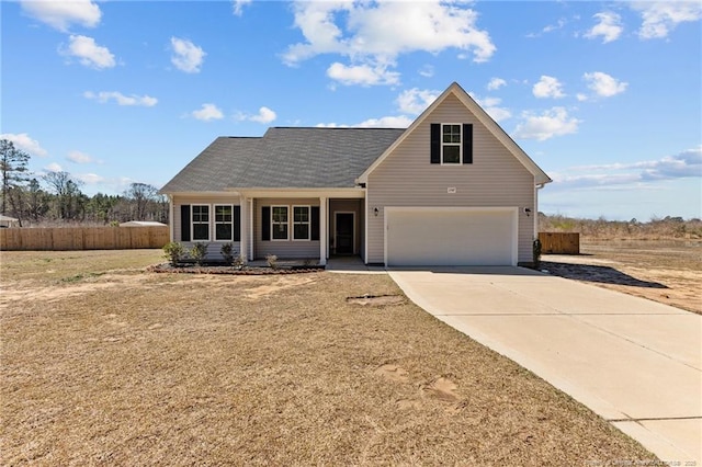 traditional-style home featuring concrete driveway, an attached garage, and fence