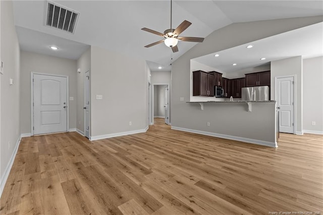 unfurnished living room featuring baseboards, visible vents, light wood finished floors, ceiling fan, and vaulted ceiling