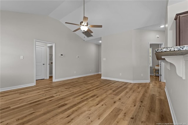 unfurnished living room featuring baseboards, light wood-style floors, a ceiling fan, and vaulted ceiling