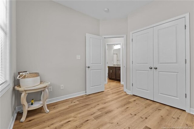 bedroom featuring a closet, baseboards, and light wood finished floors