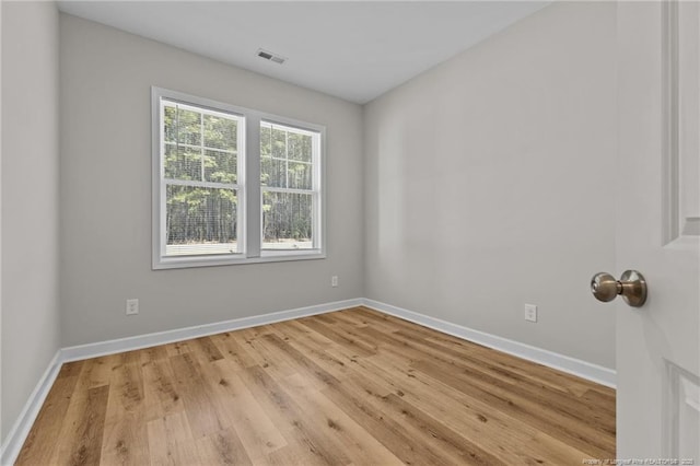 unfurnished room featuring visible vents, baseboards, and light wood-style floors