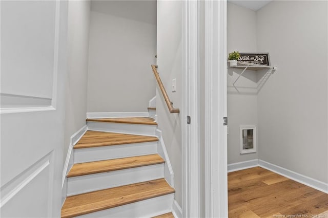 staircase featuring baseboards and wood finished floors