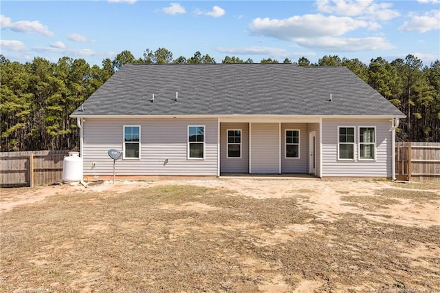 rear view of house featuring fence