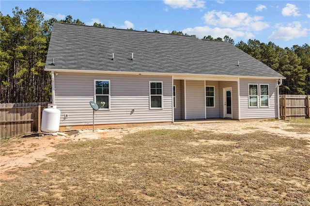 back of house featuring roof with shingles and fence