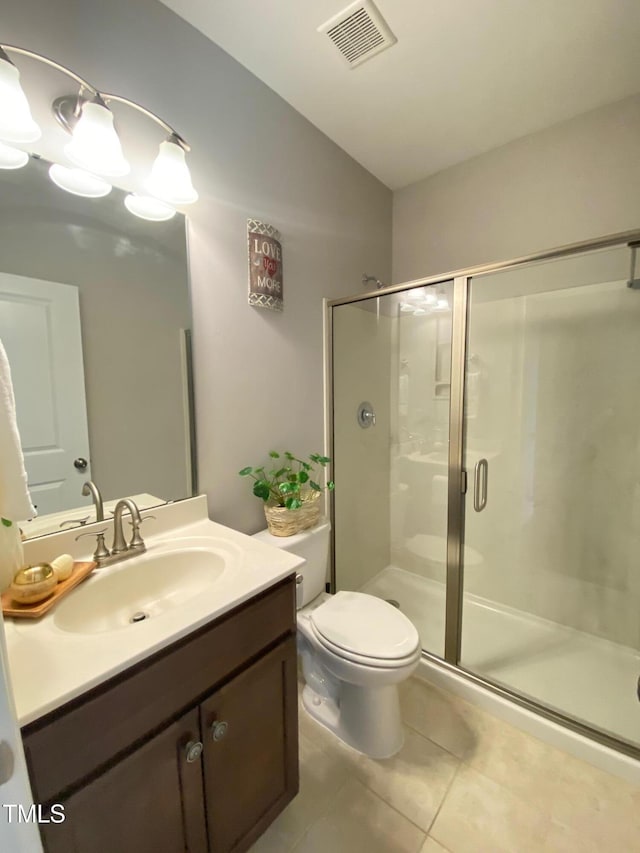 bathroom with visible vents, toilet, a shower stall, tile patterned flooring, and vanity