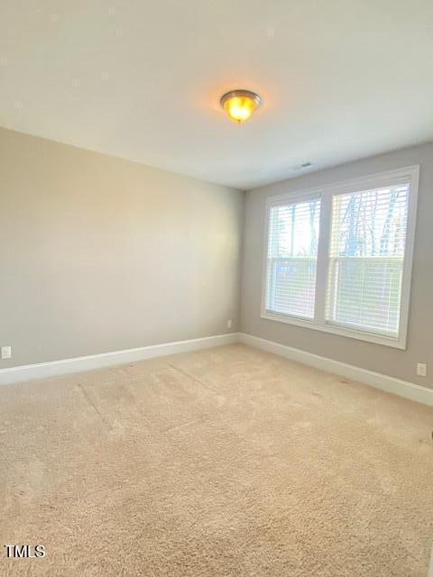 empty room with light colored carpet and baseboards