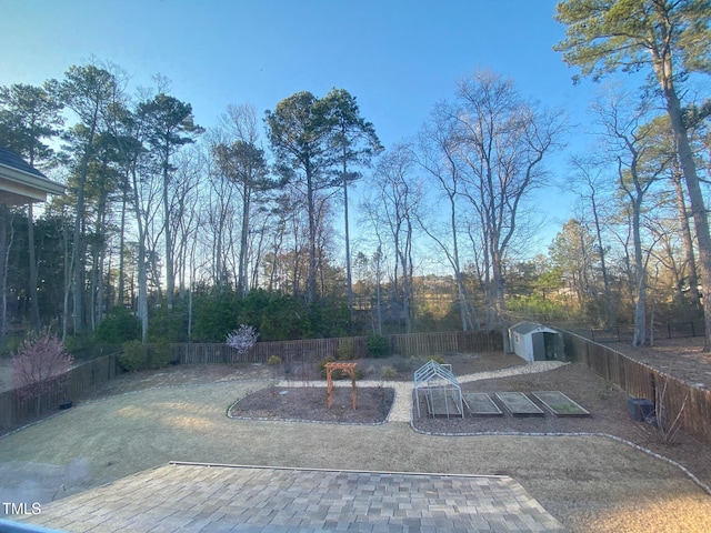 view of yard with an outbuilding, a shed, and a fenced backyard