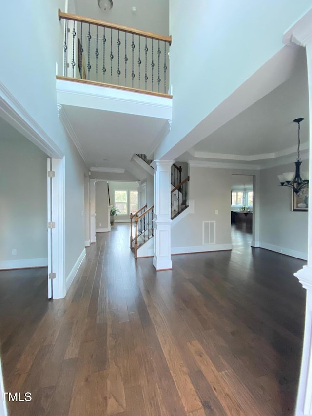 entrance foyer with visible vents, dark wood-style floors, stairway, a high ceiling, and baseboards