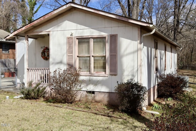 view of property exterior with a lawn, fence, and crawl space