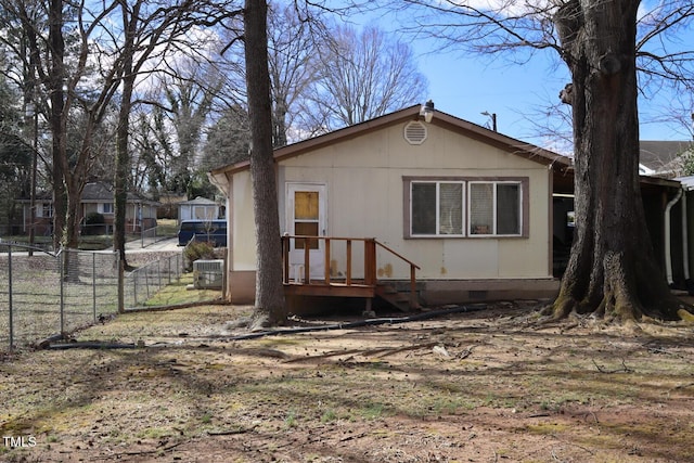 rear view of house featuring fence and crawl space