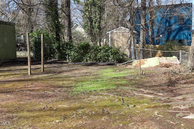 view of yard featuring an outdoor structure, a shed, and fence