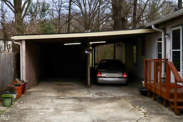 view of parking / parking lot featuring driveway and fence