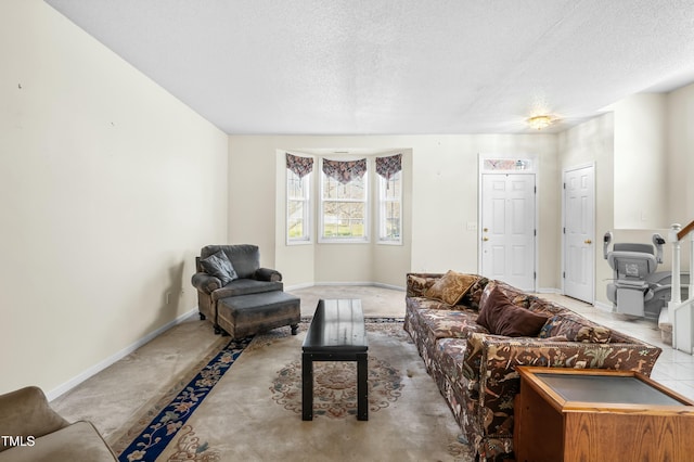 carpeted living area featuring baseboards and a textured ceiling