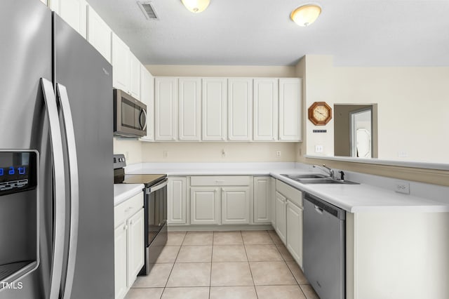 kitchen with visible vents, light tile patterned flooring, a sink, light countertops, and appliances with stainless steel finishes