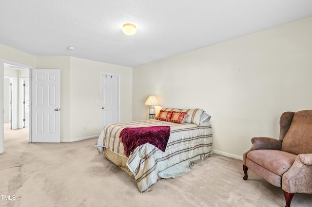 carpeted bedroom featuring baseboards and a textured ceiling