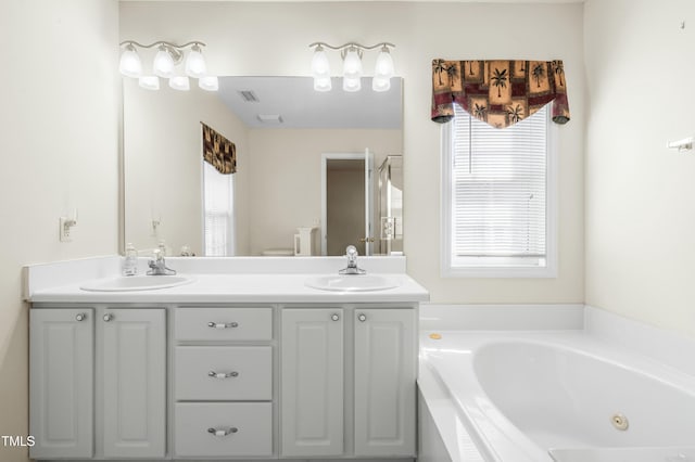 bathroom with a sink, visible vents, a jetted tub, and double vanity