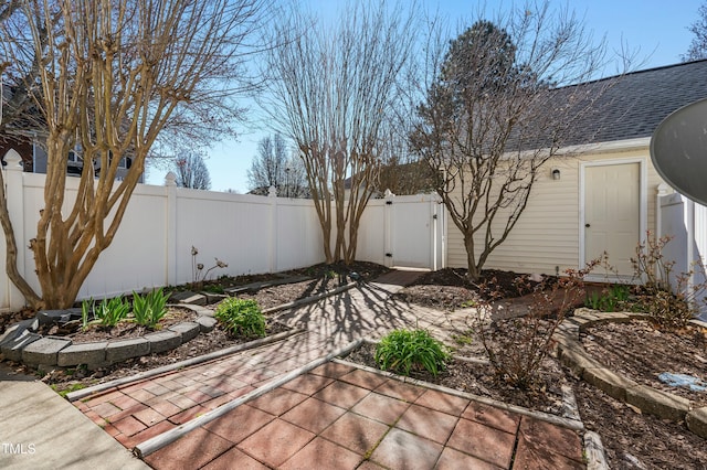 view of yard with a fenced backyard and a gate