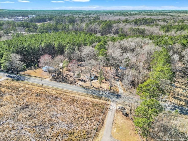 drone / aerial view featuring a wooded view