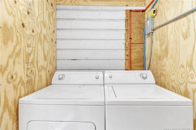 washroom with laundry area, independent washer and dryer, and wood walls