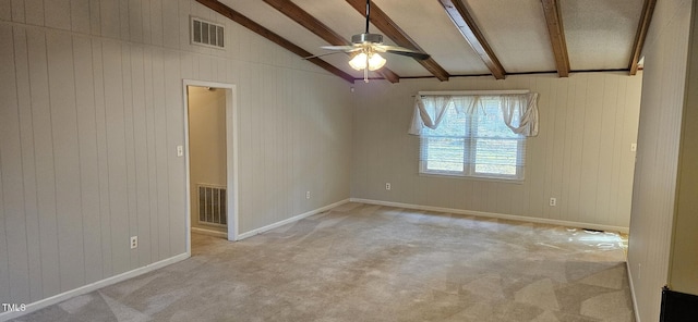 spare room with lofted ceiling with beams, visible vents, light colored carpet, and a ceiling fan