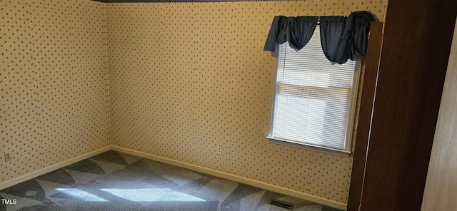 spare room featuring wallpapered walls, carpet flooring, baseboards, and visible vents