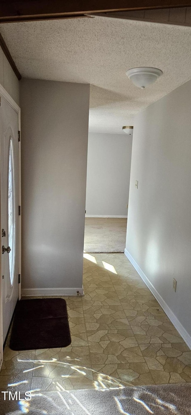 entrance foyer with a textured ceiling and baseboards