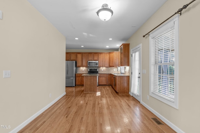 kitchen with visible vents, a sink, tasteful backsplash, appliances with stainless steel finishes, and baseboards