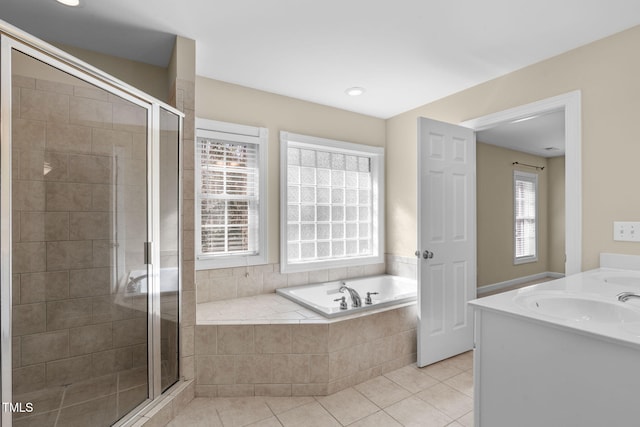 bathroom with tile patterned flooring, a stall shower, a bath, and a sink