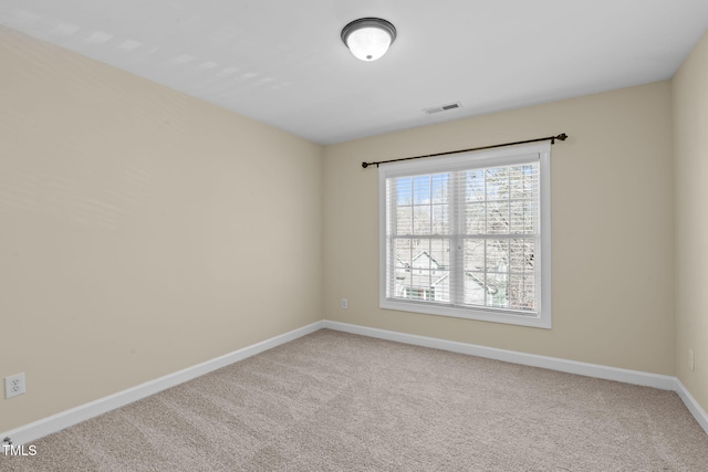 spare room with visible vents, carpet floors, and baseboards