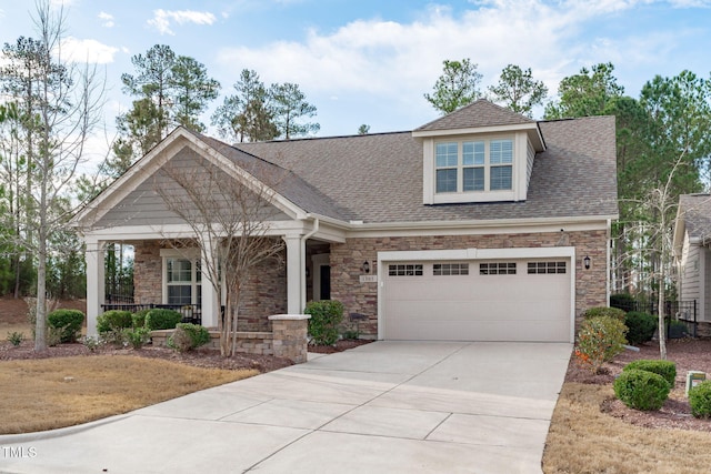 craftsman-style home with a porch, concrete driveway, roof with shingles, a garage, and stone siding