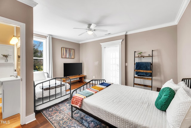 bedroom with crown molding, wood finished floors, baseboards, and visible vents