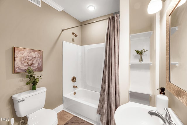 full bathroom with visible vents, toilet, shower / bath combo, a sink, and wood finished floors