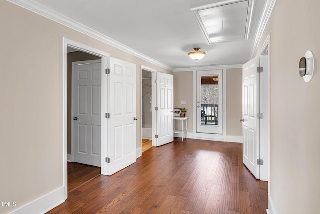 hall featuring attic access, dark wood-style floors, and crown molding