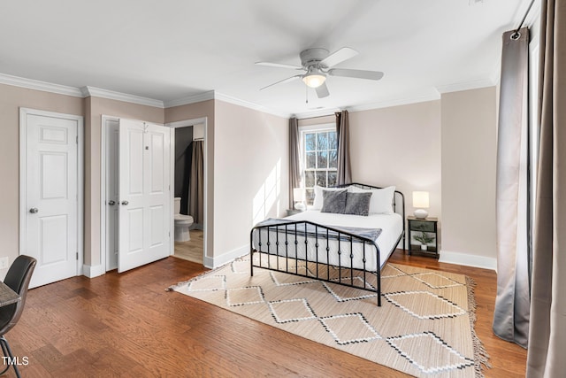 bedroom with crown molding, wood finished floors, and baseboards