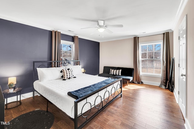 bedroom featuring baseboards, a ceiling fan, wood finished floors, and crown molding