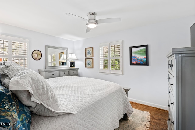 bedroom featuring a ceiling fan, wood finished floors, and baseboards