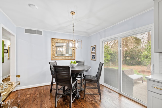 dining room featuring visible vents, baseboards, ornamental molding, wood finished floors, and a notable chandelier