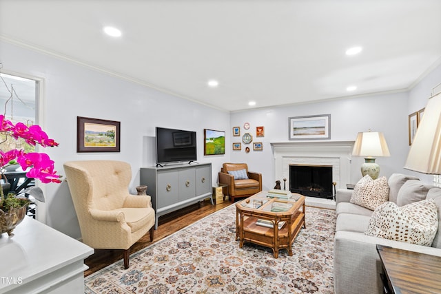 living room with recessed lighting, a brick fireplace, wood finished floors, and crown molding