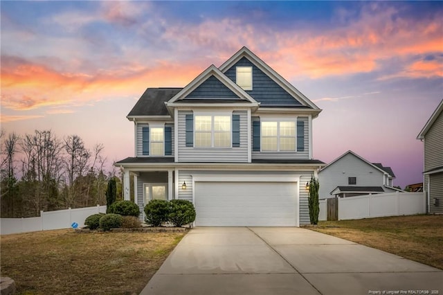 traditional home with driveway, a front lawn, a garage, and fence