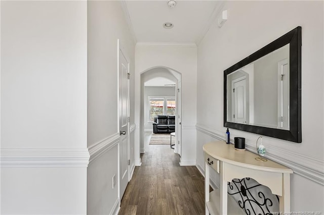 hall featuring dark wood-style floors, arched walkways, and ornamental molding