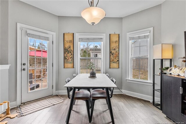 dining area with light wood-type flooring and baseboards